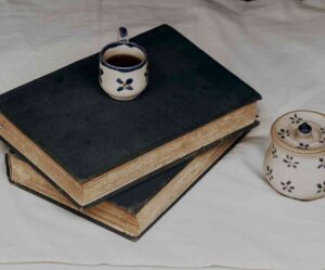Two books, a cup a nd a candle